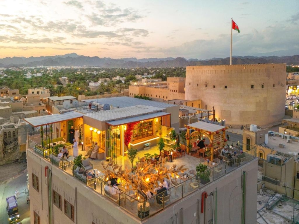Athar Cafe rooftop terrace beside Nizwa Fort at sunset