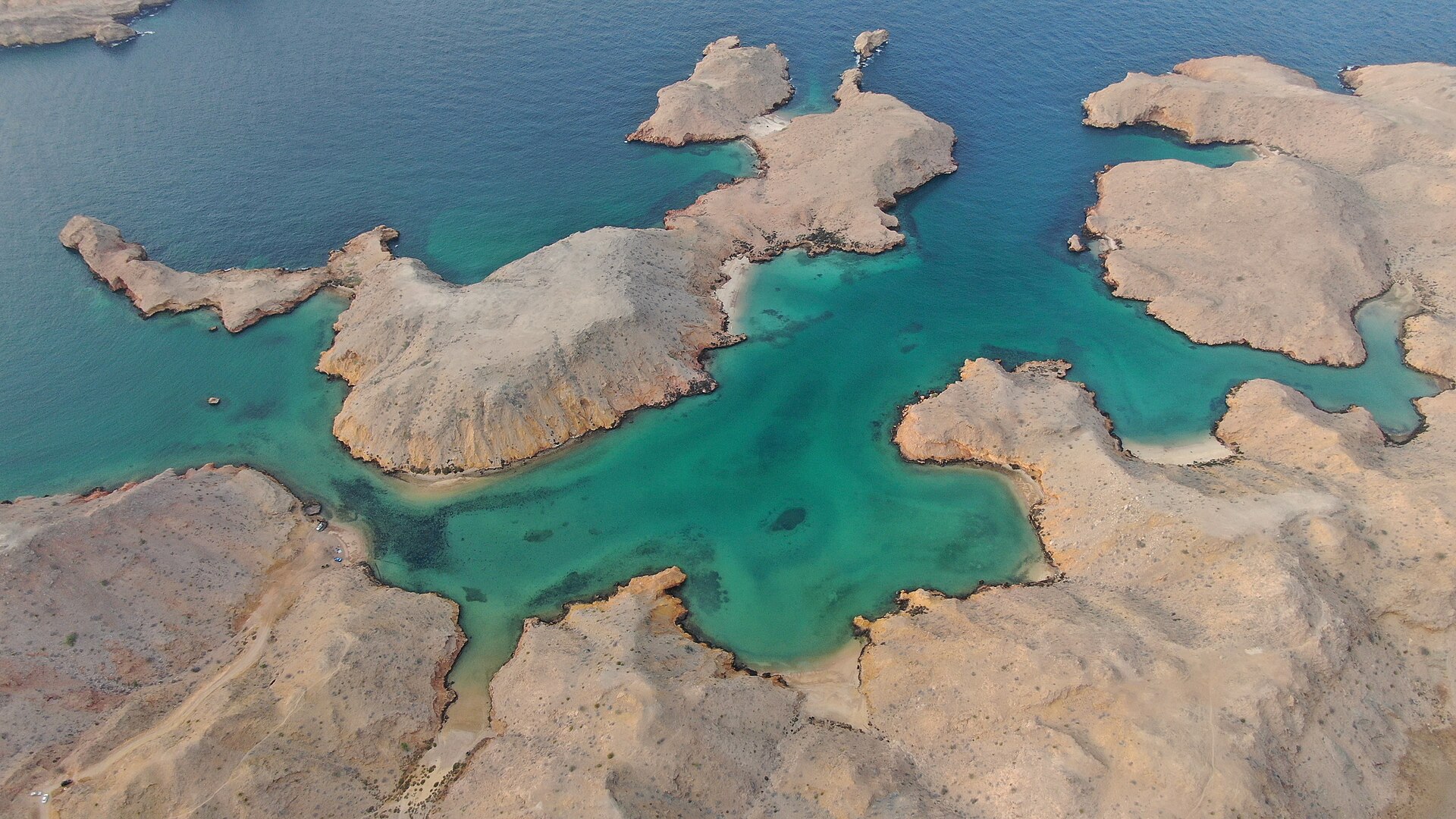 Aerial view of the turquoise coves and rocky islets of Bandar Khayran