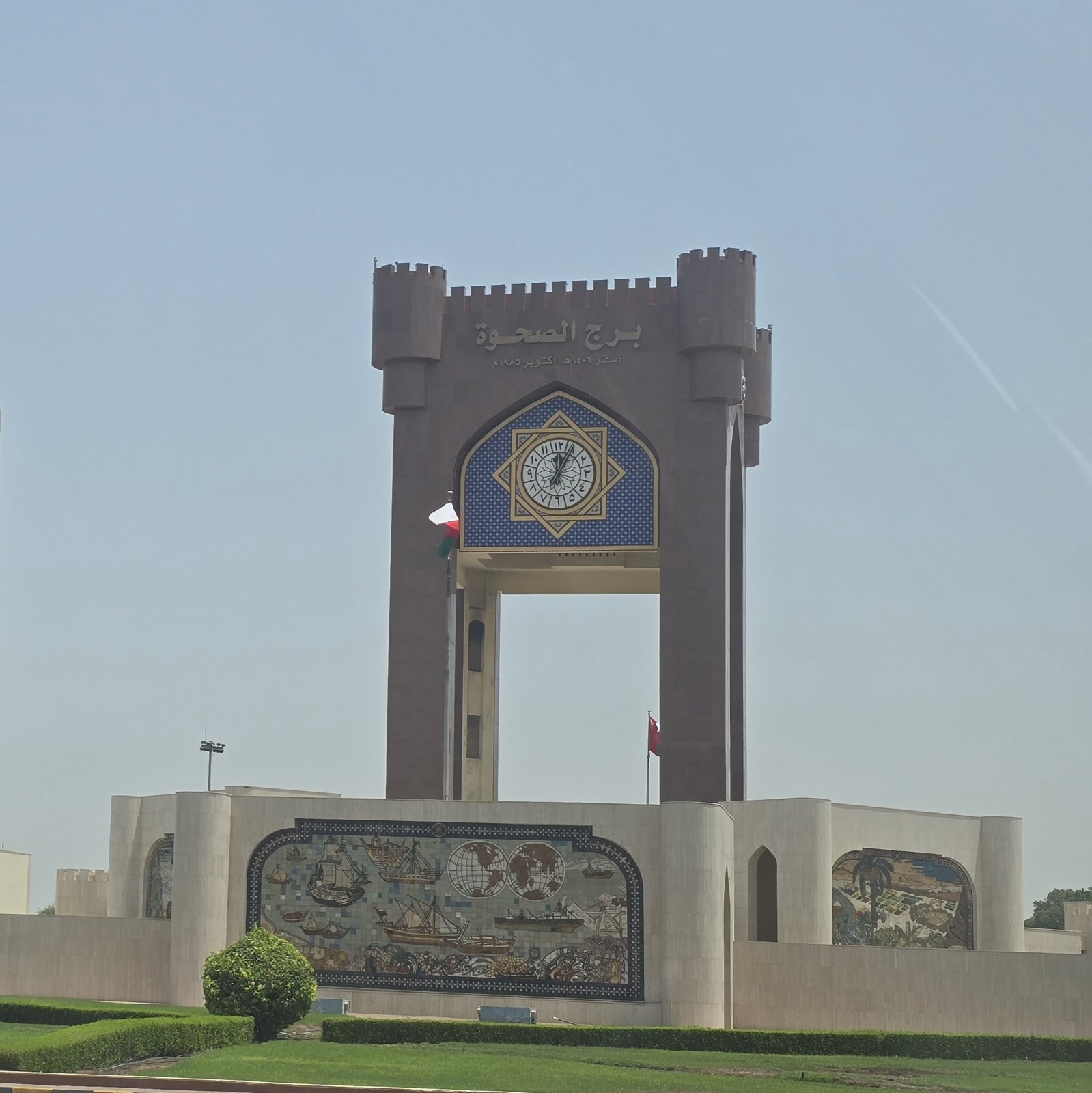 The Burj Al Sahwa clock tower and mosaic wall on its garden grounds, Seeb