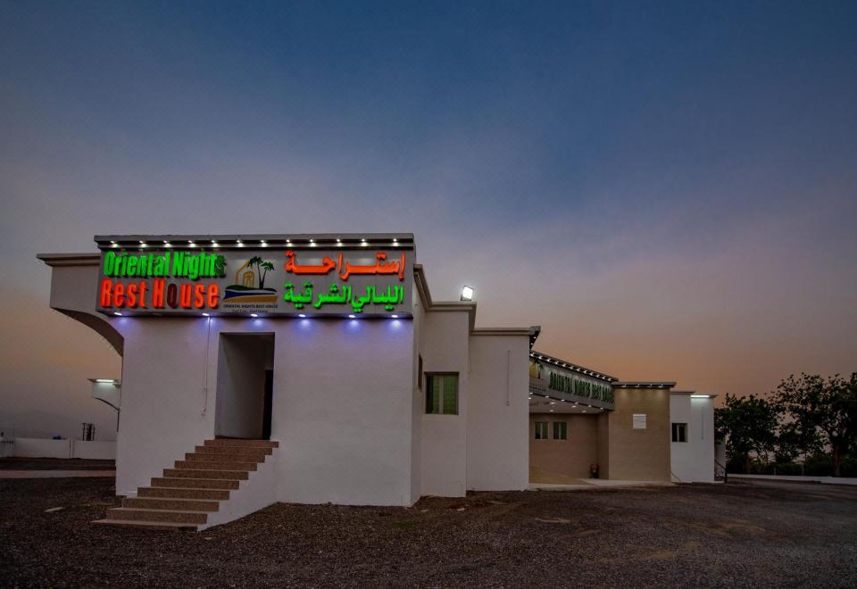 Oriental Nights Rest House at dusk with its name sign lit