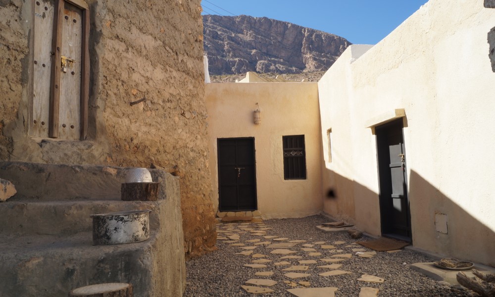 Traditional mud-brick courtyard and restored guest rooms at Sama Wakan Heritage Lodge, Wakan village
